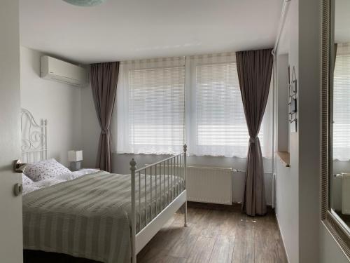 a bedroom with a bed and two windows at Apartments Vila Cvetka Bled in Bled