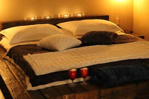 a wooden bed with two glasses of wine on it at Hilltop Hideout in Szentendre