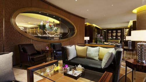 a living room with a couch and a mirror at Kempinski Hotel Taiyuan in Taiyuan
