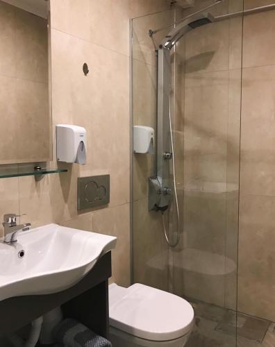 une salle de bain avec une douche, un lavabo et des toilettes dans l'établissement Bacoli Hotel, à Parga