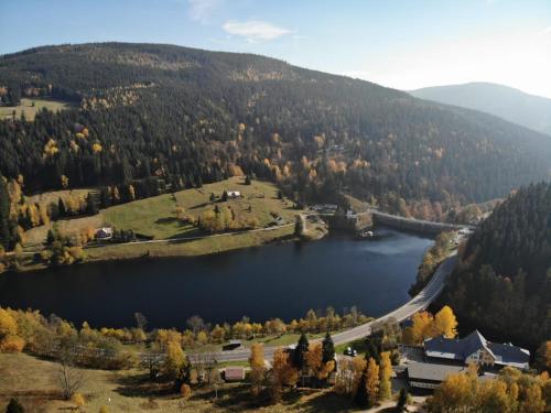 arial view of a lake with a house and a mountain at U Novotných in Špindlerův Mlýn