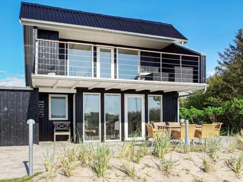 a house on the beach with a lot of windows at 6 person holiday home in Hemmet in Hemmet