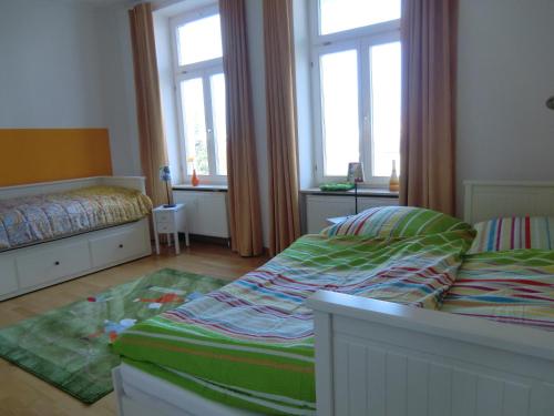 1 dormitorio pequeño con 2 camas y 2 ventanas en Ferienwohnung Ostseeglück in der Villa Marie, en Kühlungsborn