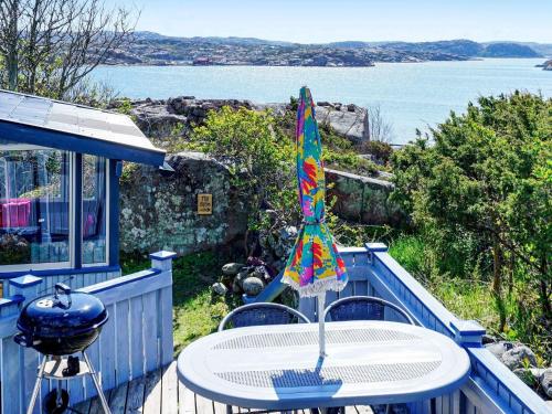 a table with an umbrella on a deck with a grill at 4 person holiday home in HAMBURGSUND in Hamburgsund