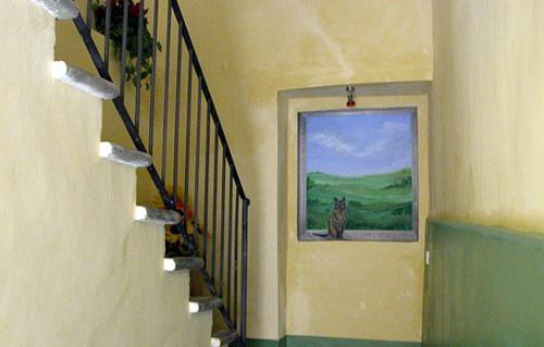 a hallway with a staircase with a painting of a dog at Residenza Sant'Emiliano in Trevi