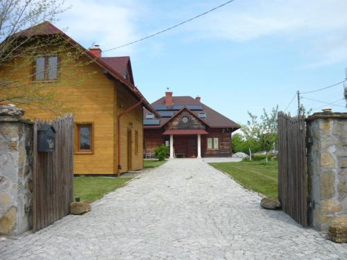 a wooden house with a gate in front of it at Wichrowe Wzgórze in Dynów