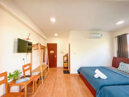 1 dormitorio con cama, mesa y TV en Lan Anh's Home en Con Dao