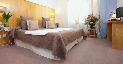 a bedroom with a large bed with a wooden headboard at La Treille in Vitrac