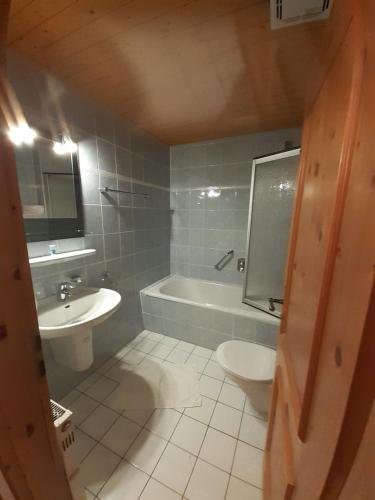 a bathroom with a tub and a sink and a toilet at Gasthof Und Hotel Maria Gern in Berchtesgaden