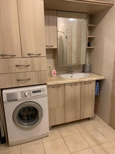 a small kitchen with a washing machine and a sink at Baltas apartamentas in Juodkrantė