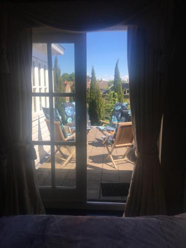Zoeterwoude的住宿－Luc's Place, jaccuzi, waterbed，透过带椅子的窗户可欣赏到庭院景色