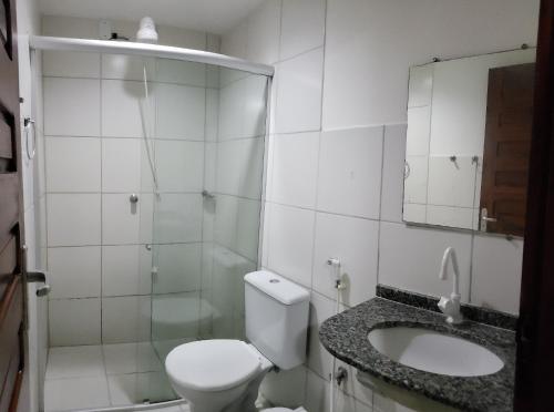 a bathroom with a toilet and a sink and a mirror at Pousada Morena Moleca in Canoa Quebrada