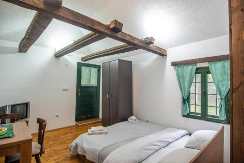 Lodge Morava في Vrnjačka Banja: غرفة نوم بسرير ومكتب ونوافذ