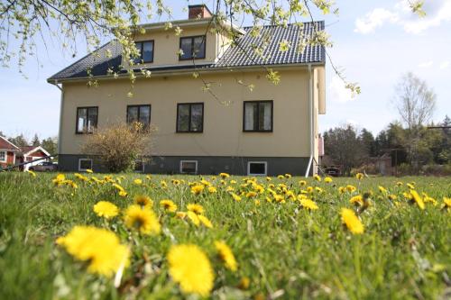 una casa con un campo de flores delante de ella en Rumskulla guesthouse en Vimmerby