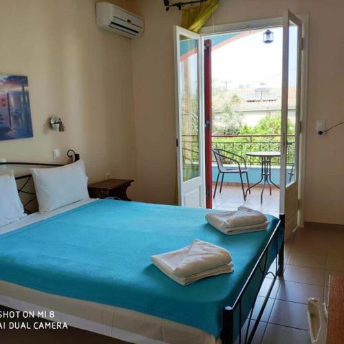 a bedroom with a bed and a patio with a table at Araxovoli Studios - Aραξοβόλι Lefkada in Tsoukalades