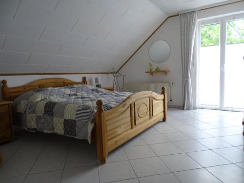 ein Schlafzimmer mit einem Holzbett und Fliesenboden in der Unterkunft Ferienwohnung Hasetal in Herzlake