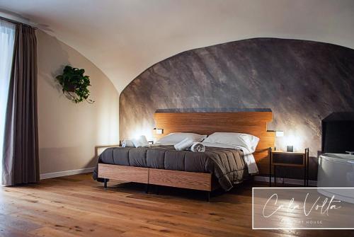 a bedroom with a large bed with a wooden headboard at Cala Volta Comfort House in Torre del Greco