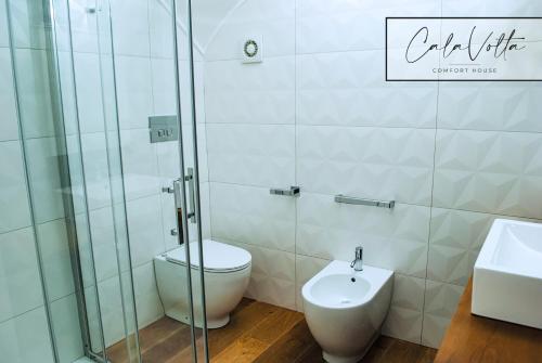 a bathroom with a toilet and a sink at Cala Volta Comfort House in Torre del Greco