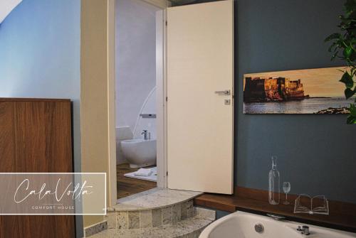 a bathroom with a white toilet and a sink at Cala Volta Comfort House in Torre del Greco