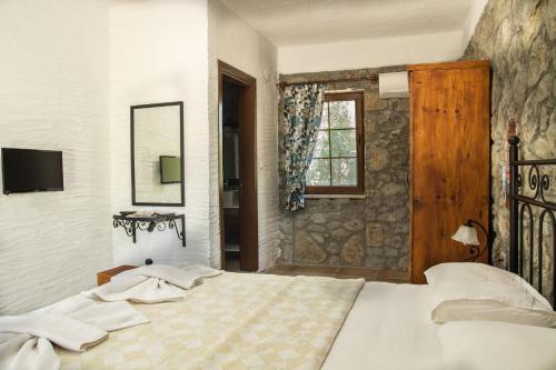 a bedroom with a large bed and a window at Doga Apartments in Kayakoy
