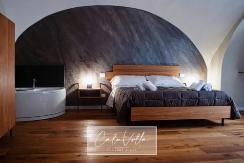a bedroom with a large bed and a bath tub at Cala Volta Comfort House in Torre del Greco