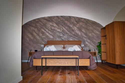a bedroom with a bed with a stone wall at Cala Volta Comfort House in Torre del Greco