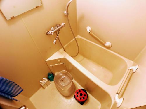 a small bathroom with a toilet and a tub at ゲストハウス ルルル 最大12名可 合宿 大家族 団体旅行にオススメ in Kochi