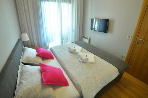 a bedroom with two beds with red and white pillows at Apartman Silver Lux in Zlatibor