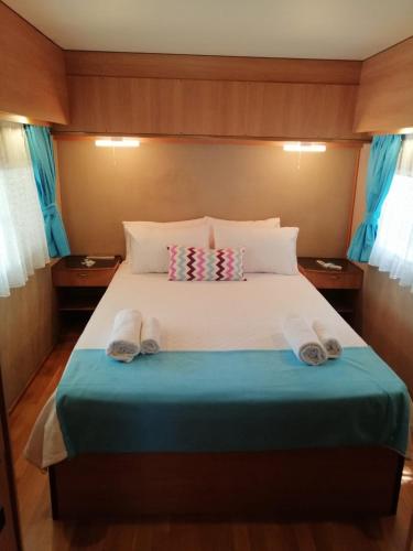 a bed in a small room with towels on it at Kara Kedi Beach Bungalow in Cıralı