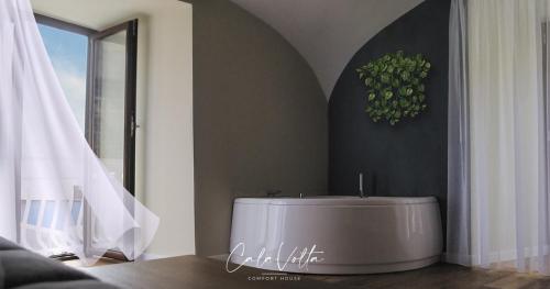 a white tub in a room with a window at Cala Volta Comfort House in Torre del Greco