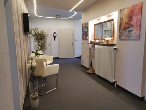 an office hallway with a waiting room with a chair at Haus am Kurpark Hotel Garni in Bad Steben