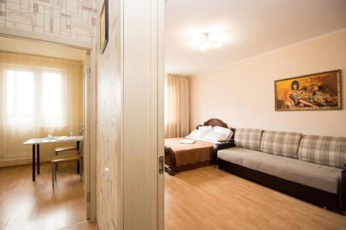モスクワにあるАпартаменты Ель 14к2のベッド、ソファ、テーブルが備わる客室です。