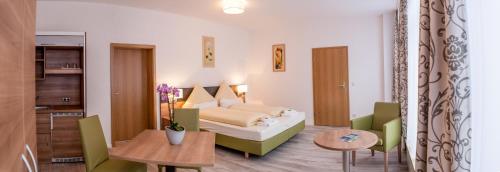 een hotelkamer met een bed en een tafel en stoelen bij EulenNest in Laubach