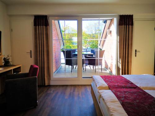 um quarto de hotel com uma cama e uma varanda com uma mesa em Feriendomizil Schlossblick em Blankenburg