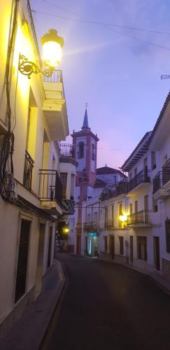 uma rua da cidade com uma torre do relógio à distância em Casita de Rosario em Cortes de la Frontera