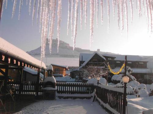 a bunch of icicles hanging from a building in the snow at A+S Penzion Podzamok in Spišské Podhradie