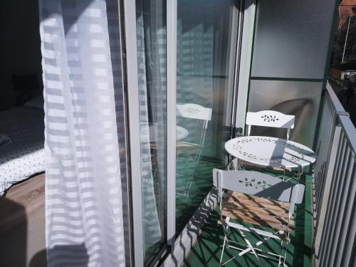 balkon z 2 krzesłami i oknem w obiekcie Le Majestic 103 w Aix-les-Bains