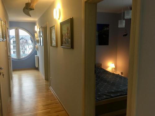 a hallway with a room with a bed and a window at Apartament Środziemnomorski in Jastrzębia Góra