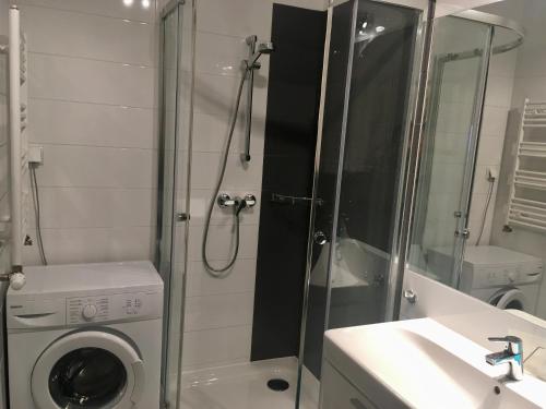 a bathroom with a shower and a washing machine at Apartament Środziemnomorski in Jastrzębia Góra