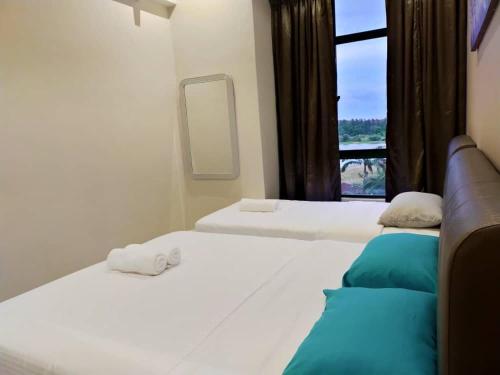 two beds in a room with a window at Austin Mahkota in Melaka