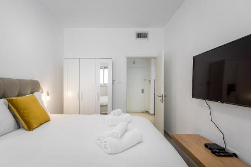 1 dormitorio con 1 cama blanca y TV de pantalla plana en Stunning 1 BDR with balcony on Sheinkin st, en Tel Aviv