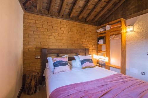 a bedroom with a large bed with white sheets and pillows at El BURGO DE OSMA ALOJAMIENTO RURAL VILLA BAGH in El Burgo de Osma