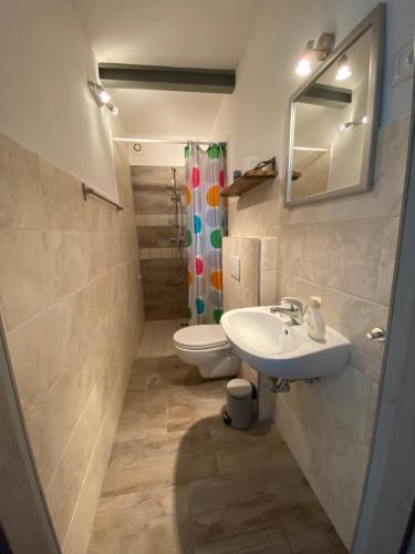 a bathroom with a sink and a toilet and a mirror at Casa Cologna B&B in Roseto degli Abruzzi