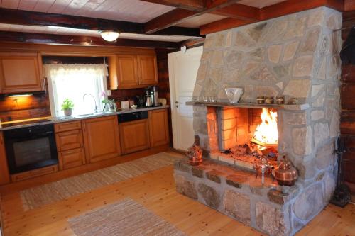 a kitchen with a stone fireplace in a room at Det Hvite Hus in Feda