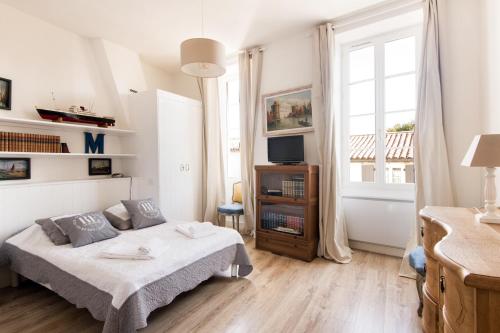 サン・マルタン・ド・レにあるMaison Antiocheの白いベッドルーム(ベッド1台、窓付)