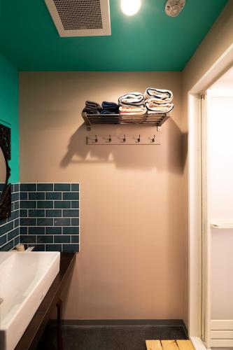 a bathroom with a sink and a shelf with towels at Room Inn Shanghai 横浜中華街 Room3 in Yokohama