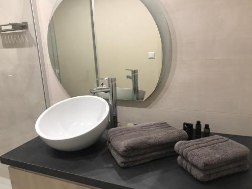 ein Badezimmer mit einem weißen Waschbecken und einem Spiegel in der Unterkunft Vivez Le Havre ! Studio en Résidence bord de mer - Port de plaisance - 3 Etoiles in Le Havre