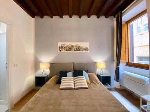 een slaapkamer met een groot bed met 2 lampen bij Heart of Rome Apartment in Rome