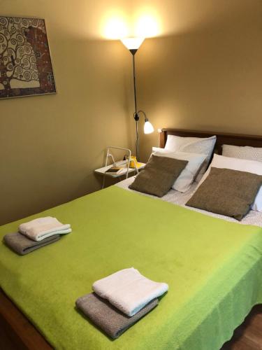 a bedroom with two beds with green sheets and towels at Pearl of Imanta in Rīga