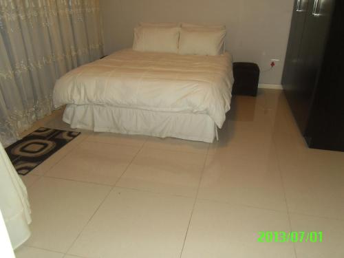 a bedroom with a bed and a tiled floor at Lily's Haven in Durban